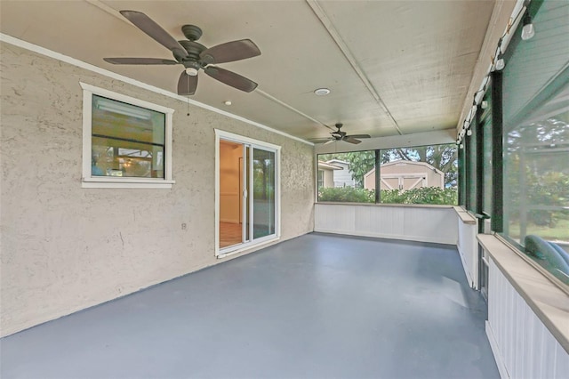 unfurnished sunroom with ceiling fan