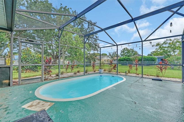 view of pool with a lawn, glass enclosure, and a patio area