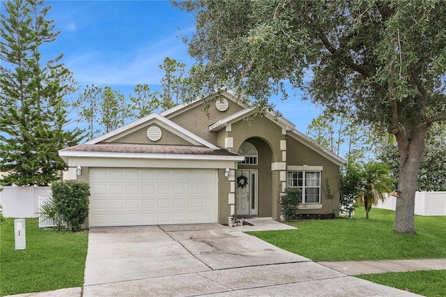 view of front of home with a garage and a front lawn