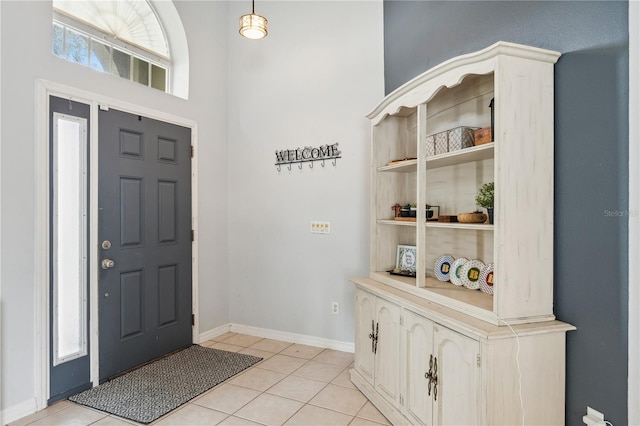 foyer with a towering ceiling and light tile patterned floors