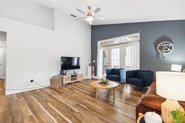 living room featuring vaulted ceiling, wood-type flooring, and ceiling fan