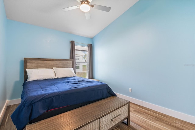 bedroom with ceiling fan, light wood-type flooring, and vaulted ceiling