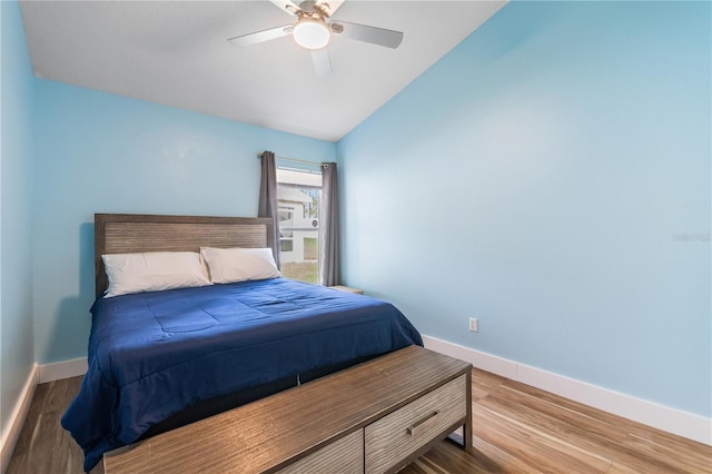 bedroom with ceiling fan, vaulted ceiling, and hardwood / wood-style floors