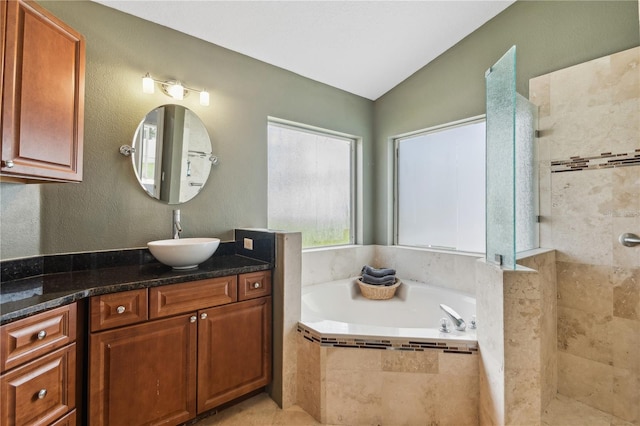 bathroom with vanity, separate shower and tub, and vaulted ceiling