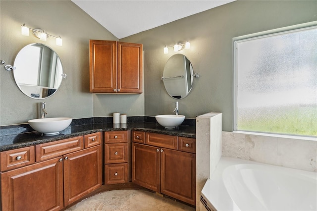 bathroom featuring vanity, lofted ceiling, and a tub