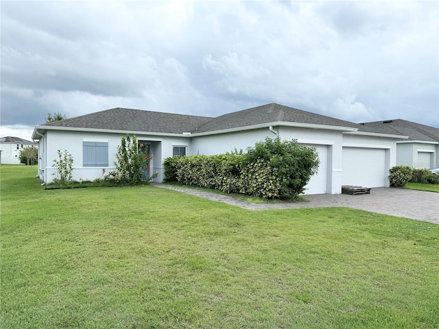 single story home with a garage and a front lawn