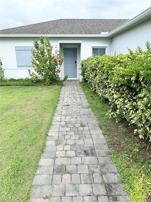 view of exterior entry featuring a yard