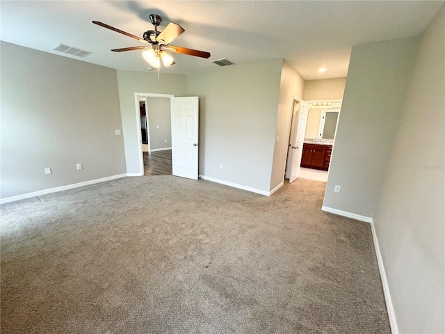 unfurnished bedroom featuring ensuite bath, ceiling fan, and light colored carpet