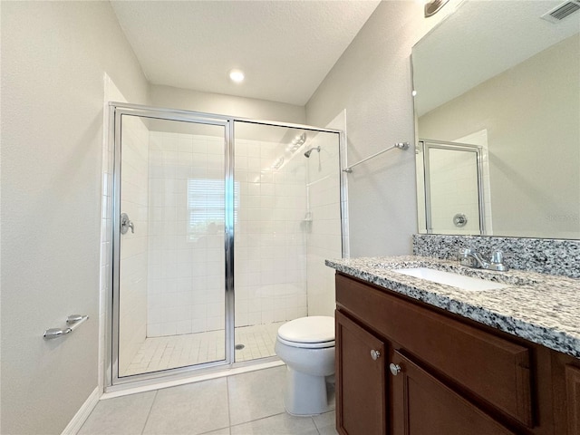 bathroom with vanity, walk in shower, a textured ceiling, toilet, and tile patterned floors