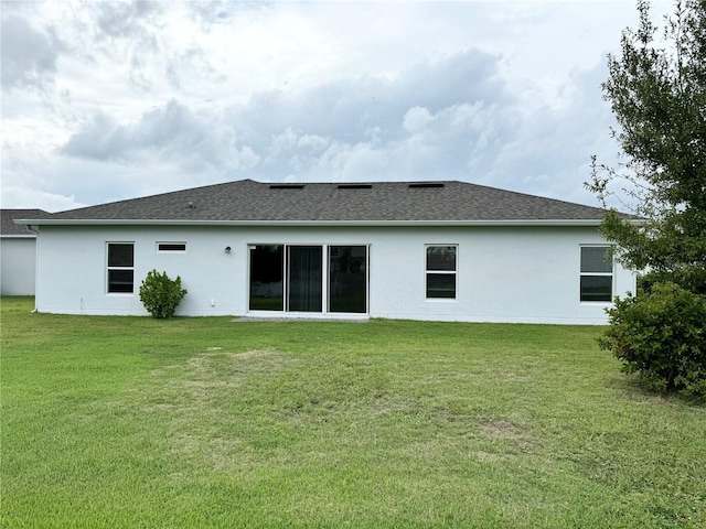 rear view of house featuring a yard