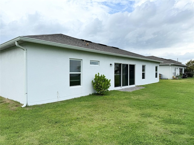 rear view of property featuring a lawn