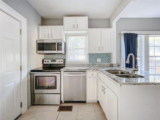 kitchen featuring sink, white cabinetry, stainless steel appliances, and a healthy amount of sunlight