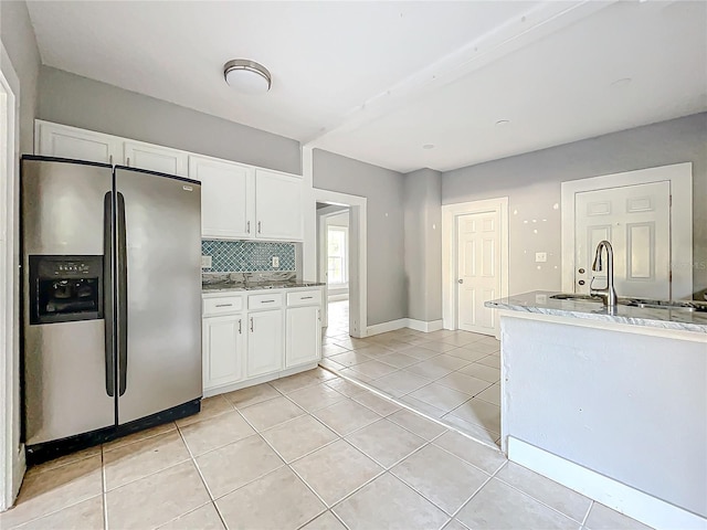 kitchen with white cabinetry, stainless steel refrigerator with ice dispenser, tasteful backsplash, and light tile patterned floors