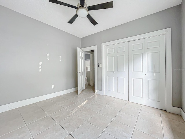 unfurnished bedroom with a closet, light tile patterned floors, and ceiling fan