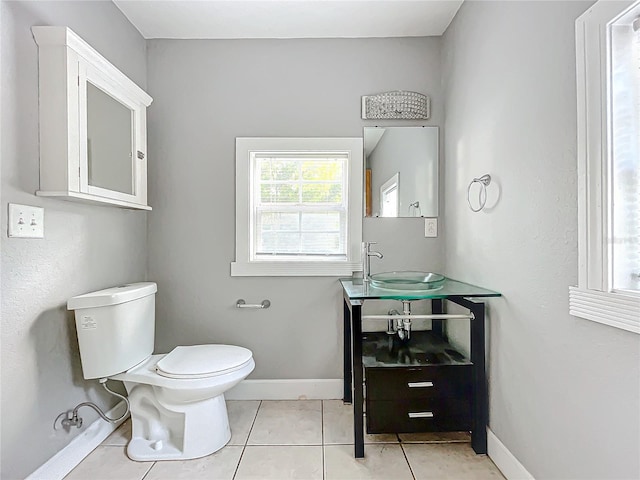 bathroom with toilet, vanity, and tile patterned flooring