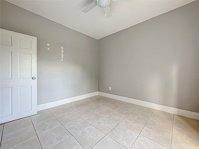 tiled empty room featuring ceiling fan