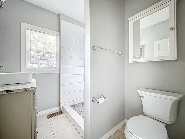 bathroom with vanity, toilet, tile patterned floors, and walk in shower