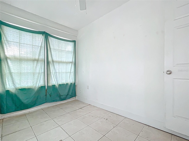 tiled empty room featuring ceiling fan