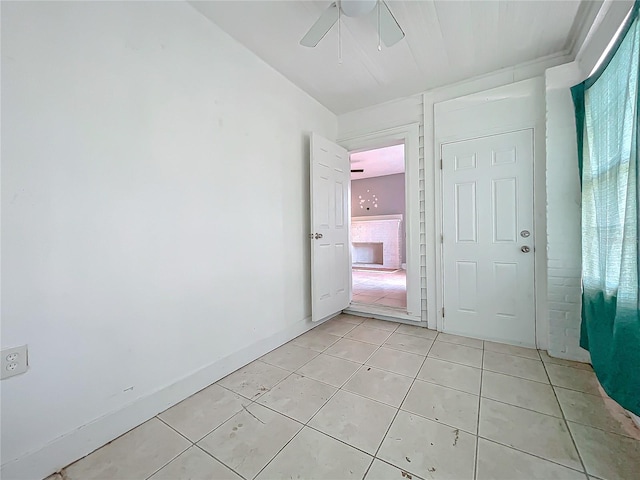 tiled empty room featuring ceiling fan