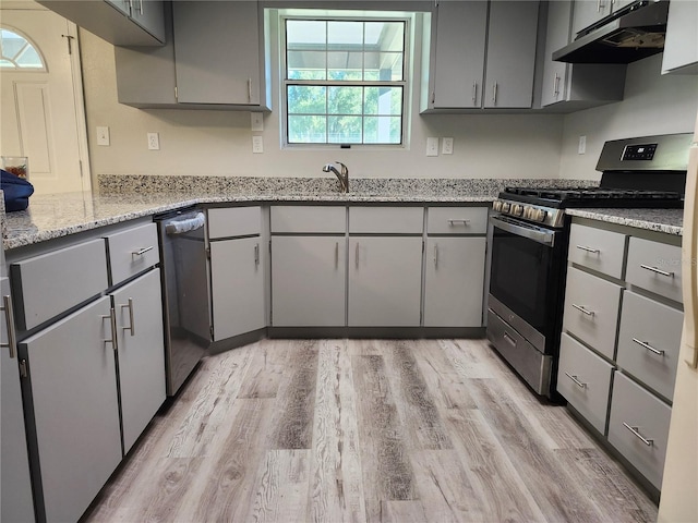 kitchen featuring light stone counters, gray cabinets, appliances with stainless steel finishes, and light hardwood / wood-style floors