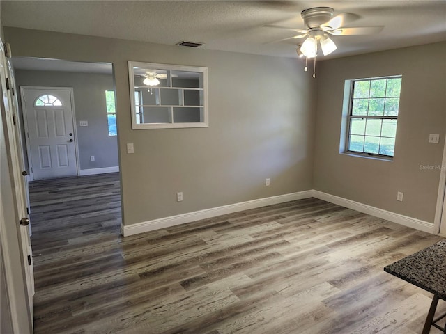 interior space with ceiling fan, a textured ceiling, and dark hardwood / wood-style floors