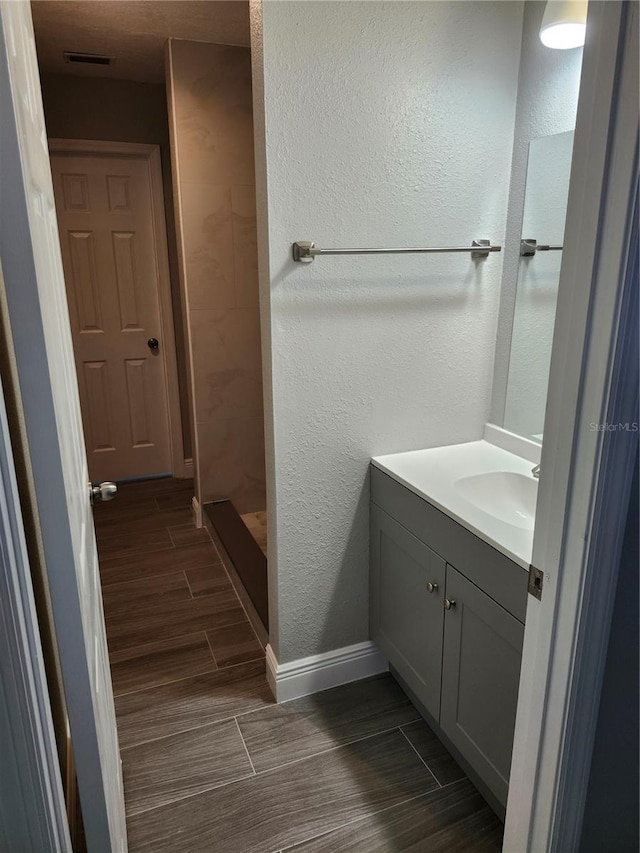 bathroom with walk in shower and vanity