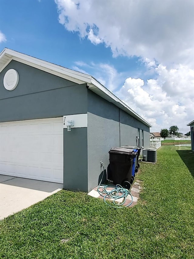 view of property exterior featuring a lawn, cooling unit, and a garage