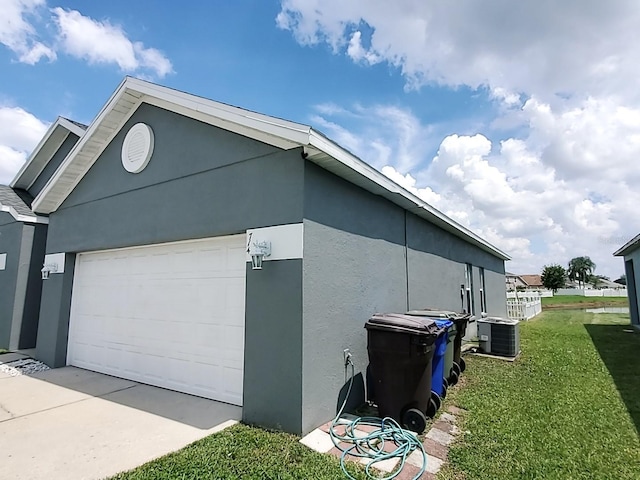 view of property exterior with a lawn and central AC