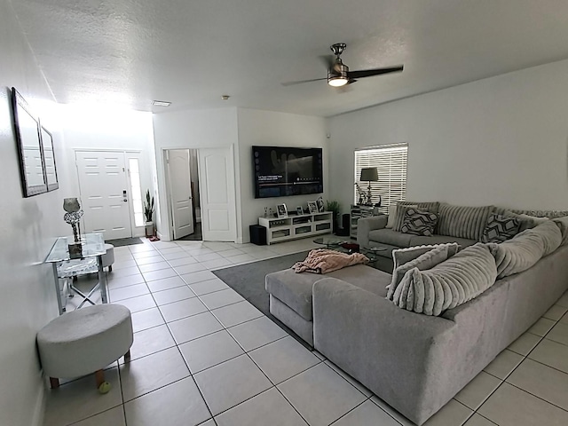 tiled living room with ceiling fan and a textured ceiling