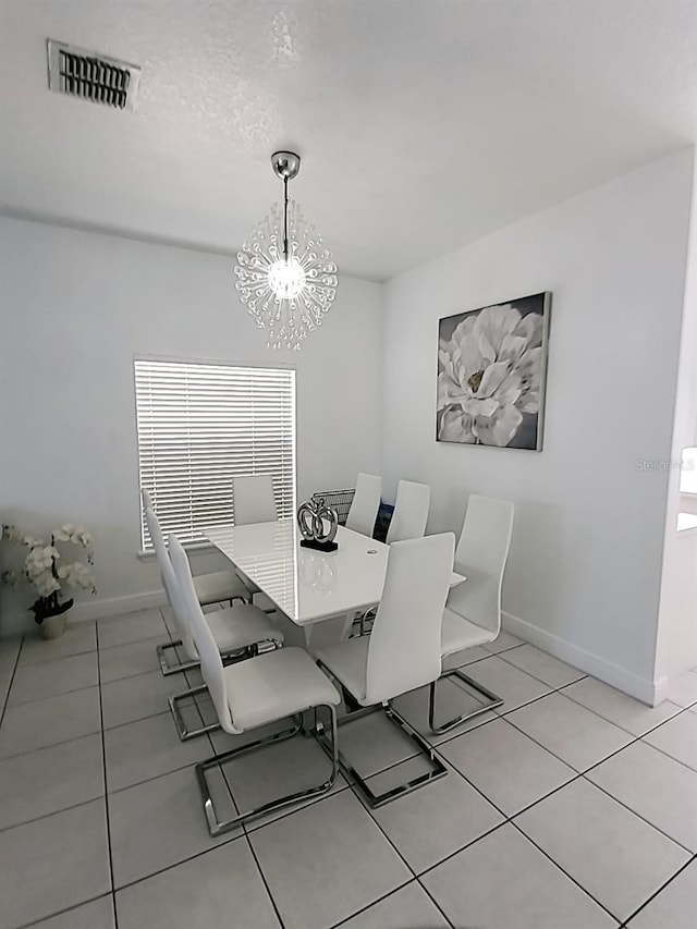 tiled dining room with a notable chandelier