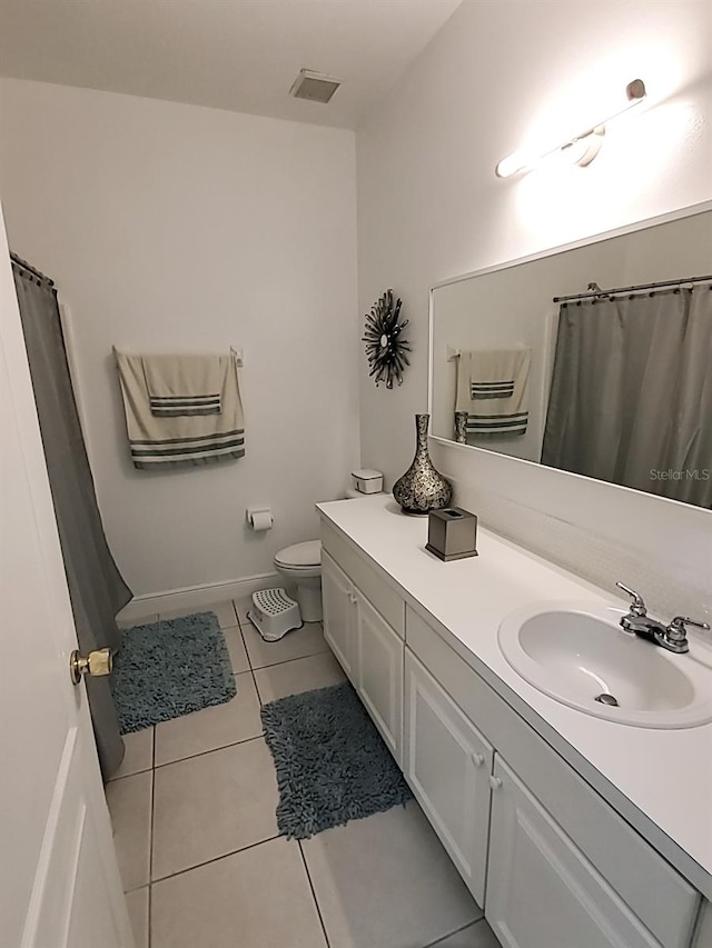 bathroom featuring tile patterned flooring, vanity, and toilet