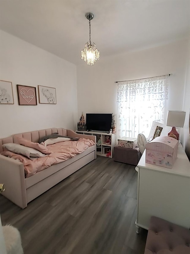 bedroom with a chandelier and dark hardwood / wood-style flooring