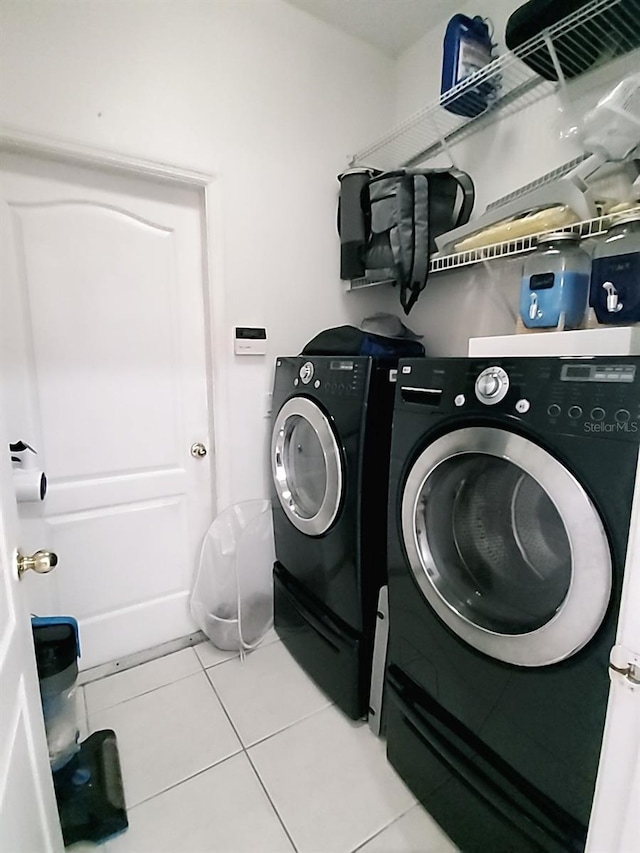 clothes washing area featuring independent washer and dryer and light tile patterned floors