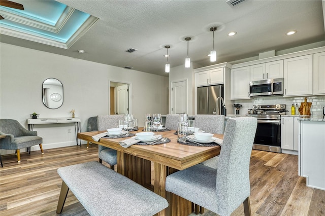 dining area featuring a textured ceiling and light hardwood / wood-style floors