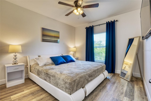 bedroom with ceiling fan and hardwood / wood-style flooring