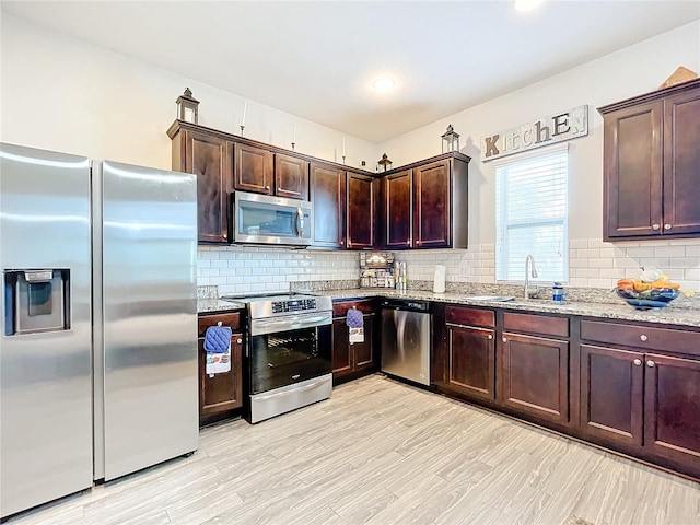 kitchen with light stone countertops, stainless steel appliances, and tasteful backsplash