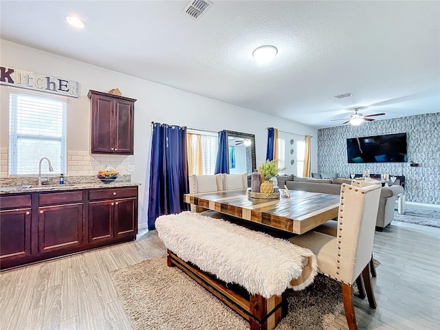 dining area featuring light hardwood / wood-style floors, sink, and ceiling fan