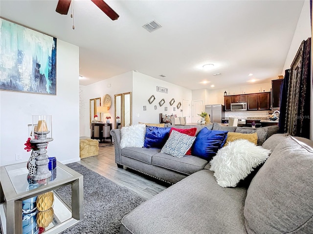 living room with ceiling fan and light wood-type flooring