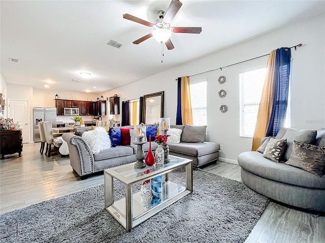 living room featuring ceiling fan and light hardwood / wood-style flooring