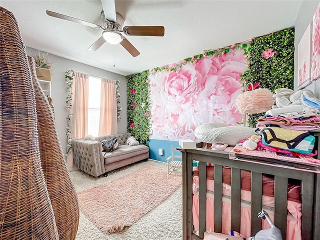 bedroom with ceiling fan, carpet floors, and a textured ceiling