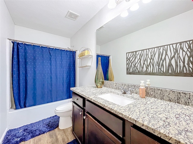 full bathroom with vanity, shower / bath combination with curtain, a textured ceiling, wood-type flooring, and toilet