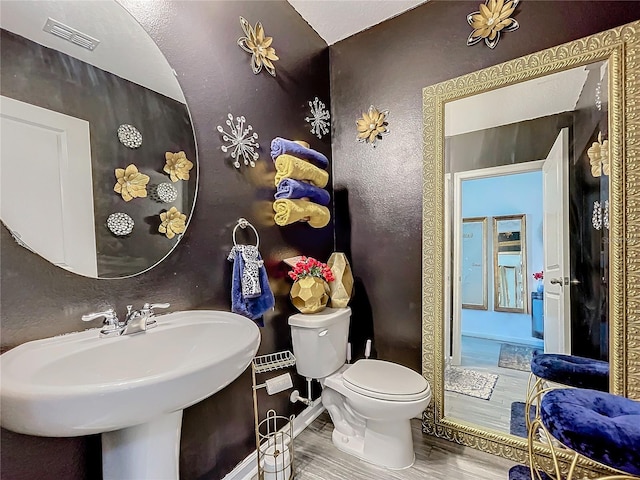 bathroom with toilet, sink, and hardwood / wood-style flooring