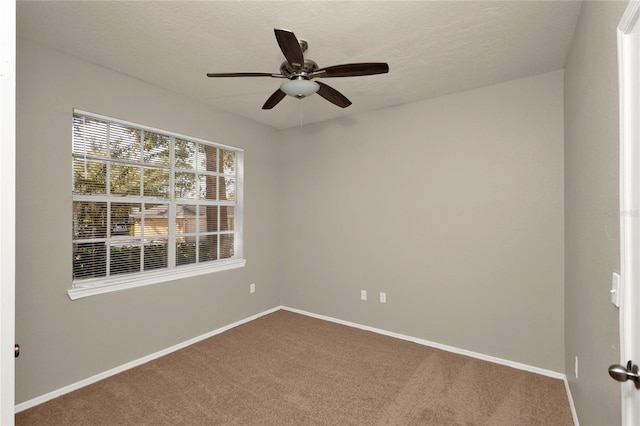 carpeted spare room with ceiling fan and a textured ceiling