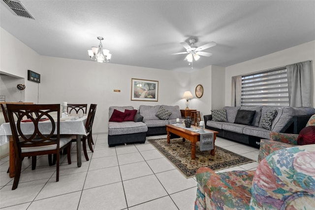 tiled living room featuring ceiling fan with notable chandelier and a textured ceiling