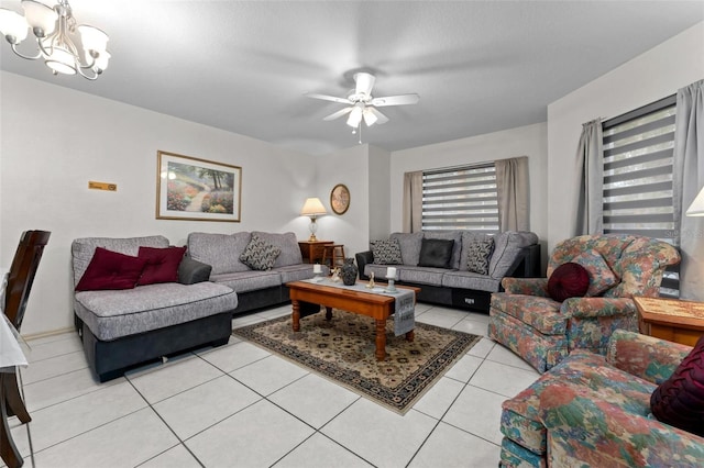 tiled living room featuring ceiling fan with notable chandelier