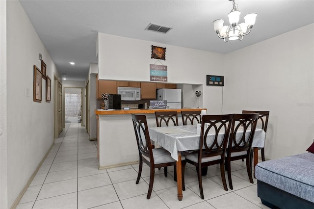 dining space featuring light tile patterned floors and a notable chandelier