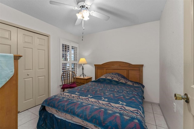 bedroom featuring a closet, ceiling fan, light tile patterned flooring, and a textured ceiling