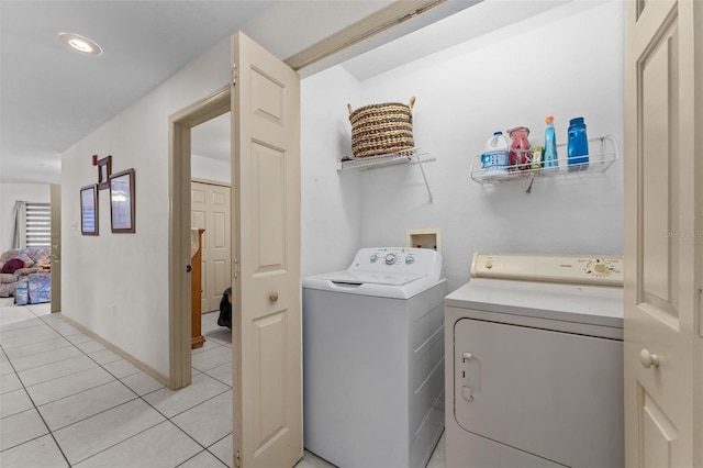 laundry room with separate washer and dryer and light tile patterned flooring