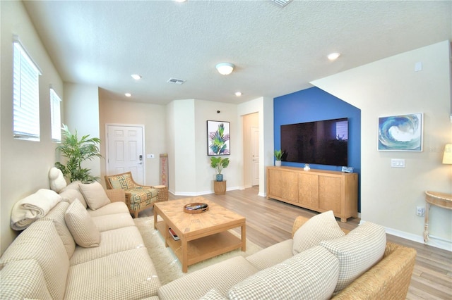 living room featuring a textured ceiling and light hardwood / wood-style floors