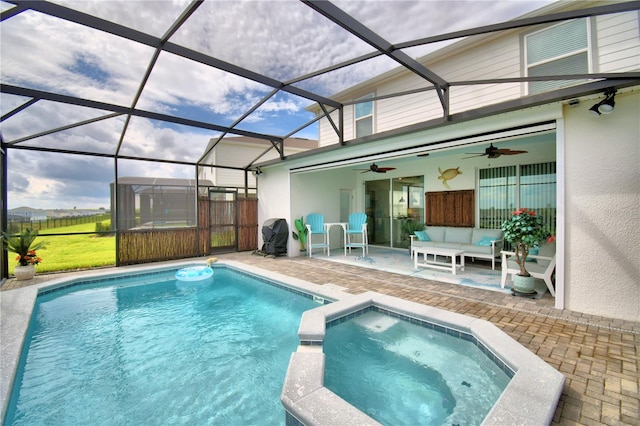 view of swimming pool featuring a patio, an in ground hot tub, ceiling fan, and glass enclosure